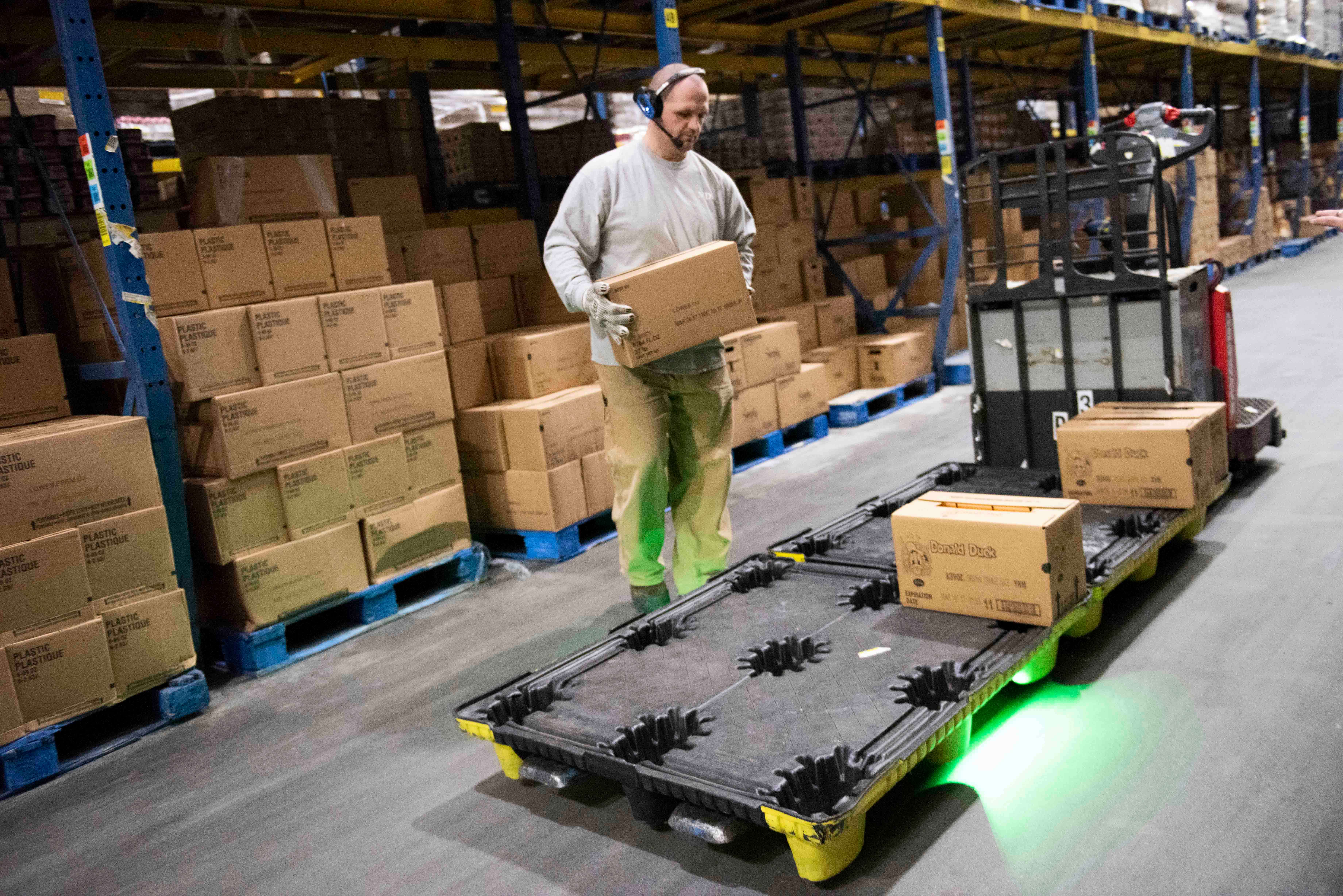 Warehouse operator using Raymond's pick 2 pallet operator assist while picking. 